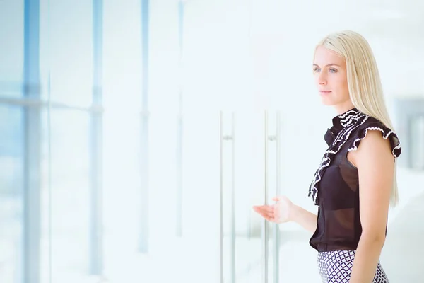 Una hermosa mujer rubia de negocios abre la puerta de la oficina . — Foto de Stock