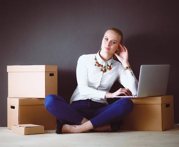 Žena sedí na podlaze boxy s notebookem. Podnikatelka — Stock fotografie