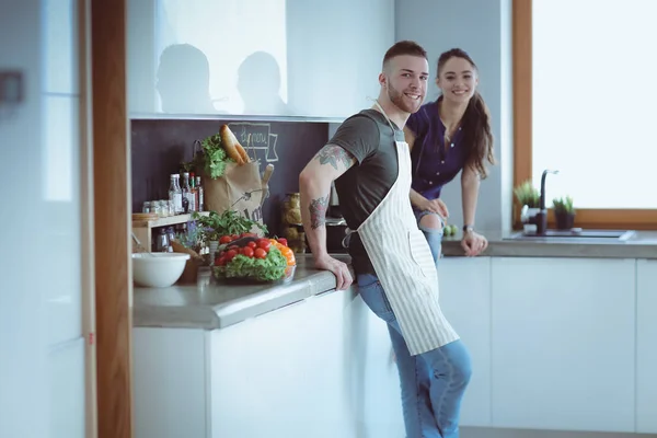 Belo jovem casal está se divertindo na cozinha em casa — Fotografia de Stock