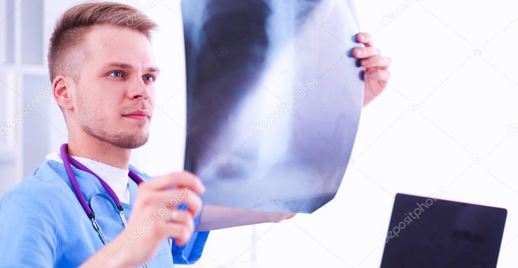 Portrait of a male doctor with x-ray picture spine in the medical office