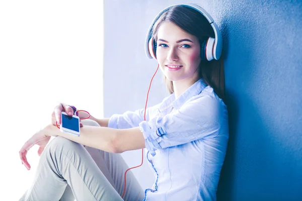 Giovane ragazza felice seduta sul pavimento e ascoltare musica — Foto Stock