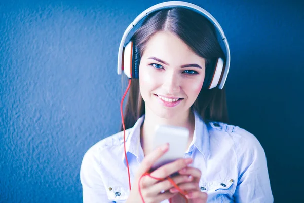 Gelukkig meisje zittend op de vloer en muziek luisteren — Stockfoto