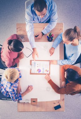 İş adamları toplantıda, ofiste oturup tartışıyorlar.