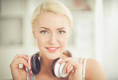 Evdeki genç ve güzel kadın kanepede oturup müzik dinliyor.