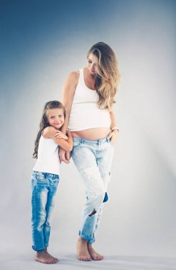 Hamile bir kadının karnını tutan mutlu çocuk. Anneler Günü konsepti