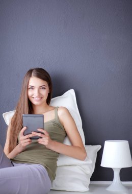 bir yastık ve uçak tablo ile katta oturan güzel esmer kadın