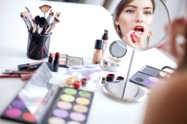 Genç güzel kadın ayna, Masa başında oturan yakınındaki makyaj yapma