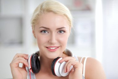 Evdeki genç ve güzel kadın kanepede oturup müzik dinliyor.