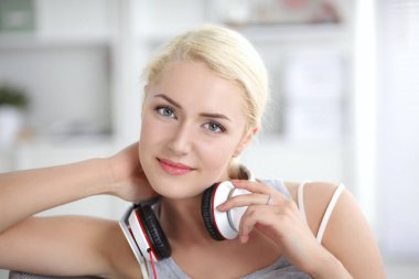 Evdeki genç ve güzel kadın kanepede oturup müzik dinliyor.