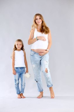 Hamile bir kadının karnını tutan mutlu çocuk. Anneler Günü konsepti