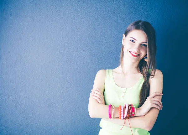 Portrait of a young smiling woman on a gray wall background — Stock Photo, Image