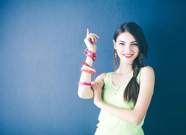 Portret van een jonge glimlachende vrouw op een grijze achtergrond — Stockfoto