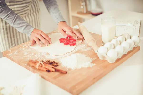 Vrouw maakt kerstkoekjes in de keuken — Stockfoto