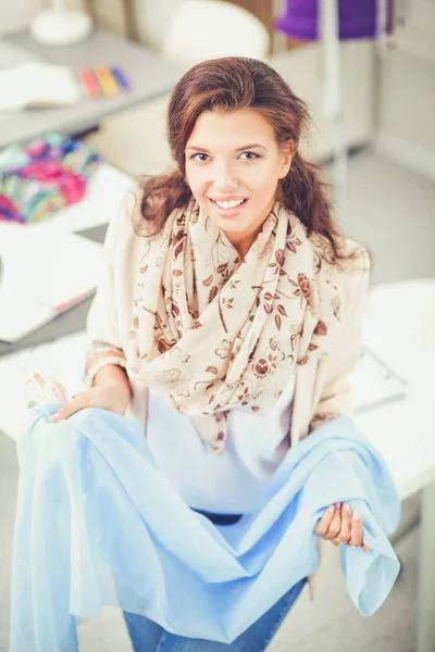 Sorrindo designer de moda feminina sentado na mesa de escritório — Fotografia de Stock