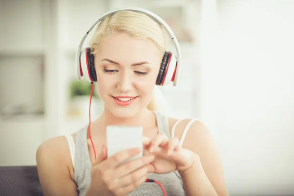 Joven hermosa mujer en casa sentada en el sofá y escuchando música —  Fotos de Stock