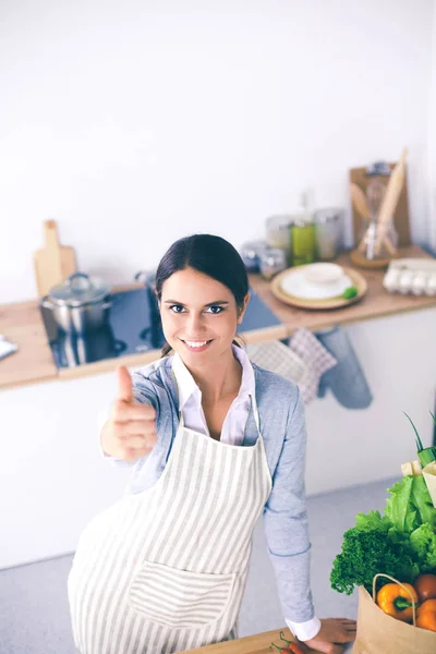 Žena, aby zdravé potraviny stojící usmívající se v kuchyni — Stock fotografie