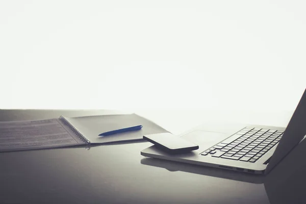 Laptop z stosem folderów na stole na białym tle — Zdjęcie stockowe