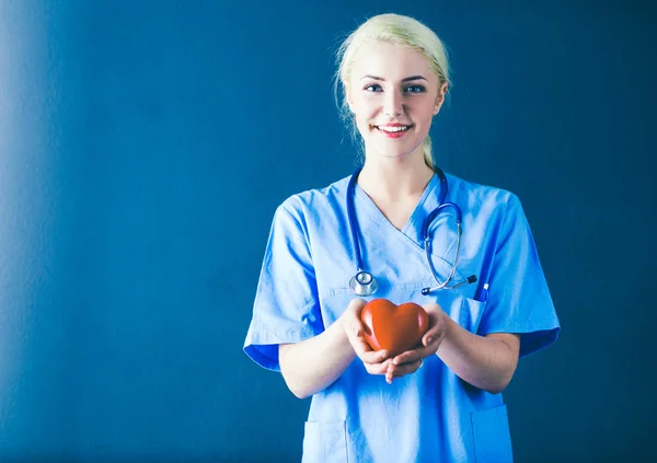 Jovem médica com estetoscópio segurando coração — Fotografia de Stock