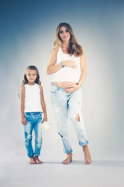 Happy child holding belly of pregnant woman. Mothers day concept — Stock Photo, Image