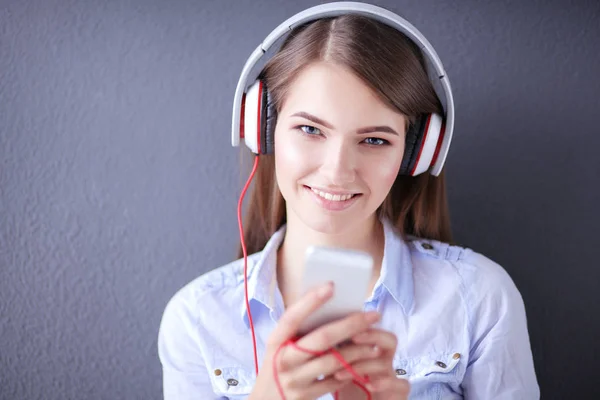 Jovem menina feliz sentado no chão e ouvir música — Fotografia de Stock