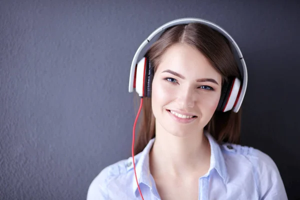 Gelukkig meisje zittend op de vloer en muziek luisteren — Stockfoto