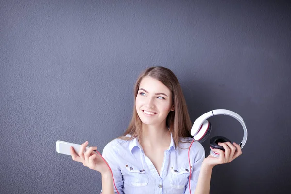 Young happy girl sitting on floor and listening music — Stock Photo, Image