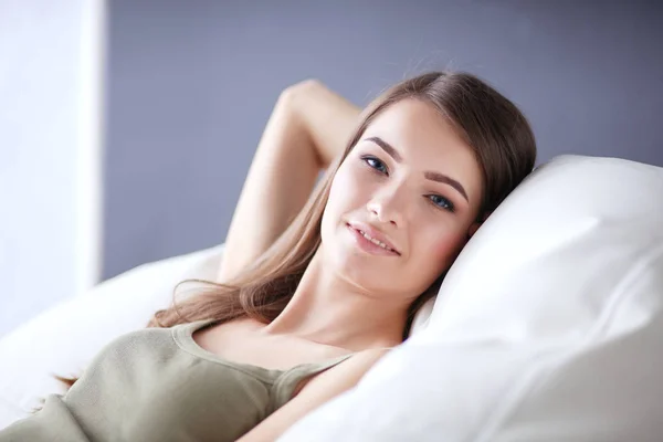 Gros plan d'une jeune femme souriante allongée sur le canapé — Photo