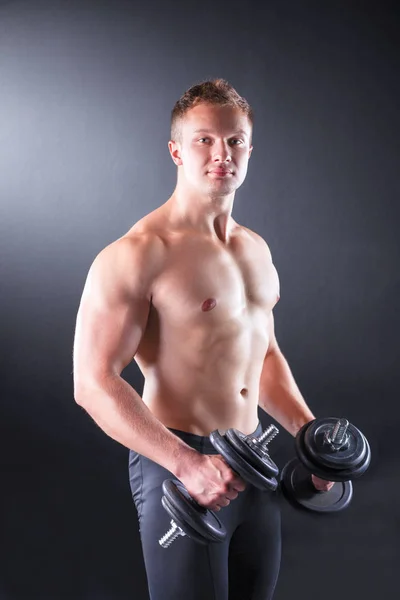 Handsome muscular man working out with dumbbells — Stock Photo, Image