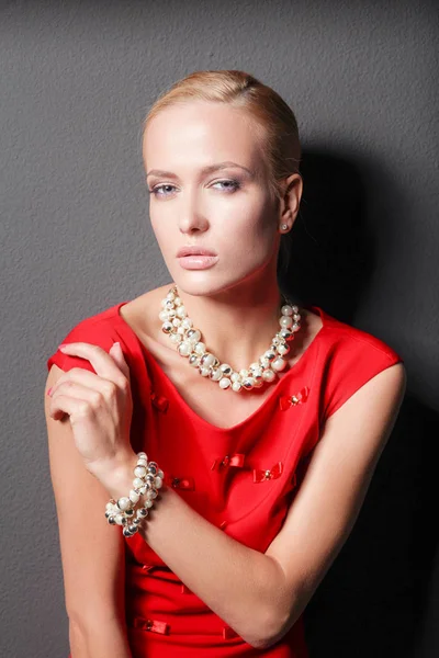 Portrait of young woman on red dress, isolated black background — Stock Photo, Image