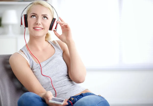 Joven hermosa mujer en casa sentada en el sofá y escuchando música —  Fotos de Stock