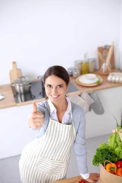 Vrouw maken van gezonde voeding staande glimlachend in keuken — Stockfoto