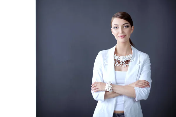Portret van een jonge vrouw met parels, staande op een grijze achtergrond — Stockfoto