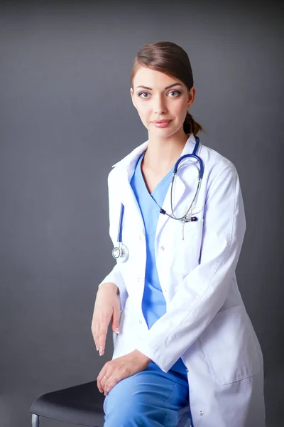 Doctor woman with stethoscope isolated on grey background — Stock Photo, Image