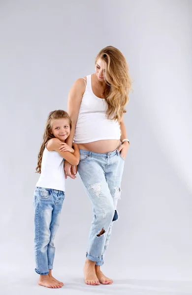 Happy child holding belly of pregnant woman. Mothers day concept — Stock Photo, Image