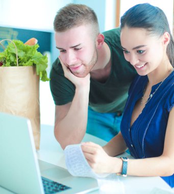 Çift evde mutfak içinde laptop ile onların fatura ödeme