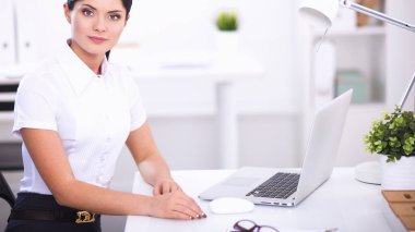 Ofiste masa başında oturan çekici bir iş kadını.