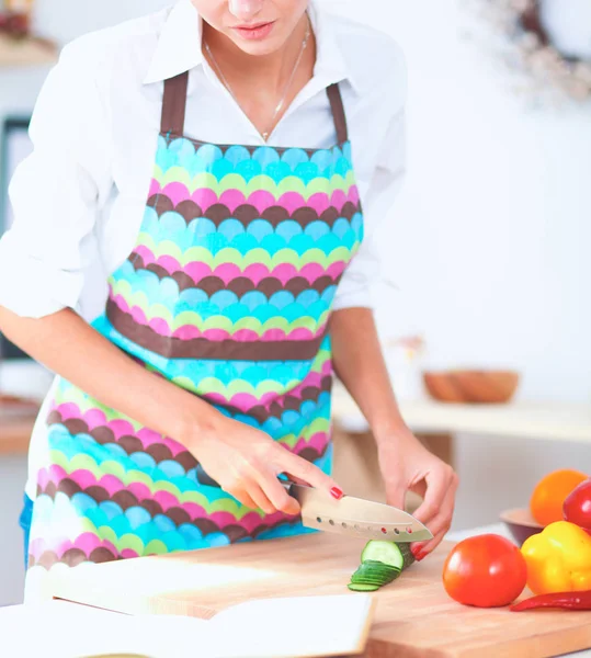 Leende kvinna tillagar sallad i köket — Stockfoto