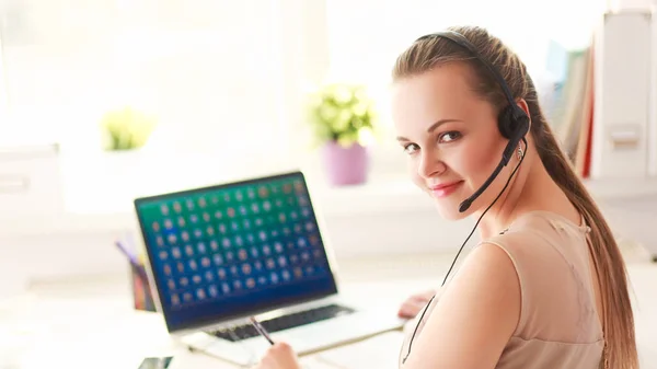 Kvinna med dokument sittande på skrivbordet och laptop — Stockfoto