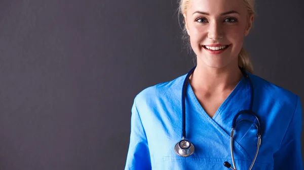 Jonge arts vrouw met stethoscoop geïsoleerd op grijze achtergrond — Stockfoto