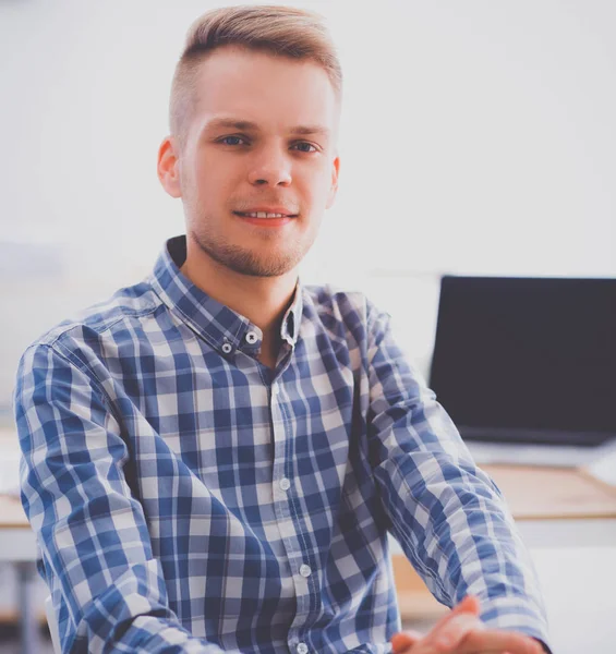 Молодой бизнесмен работает в офисе, сидит за столом — стоковое фото