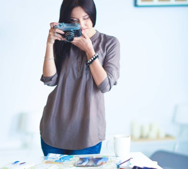 Genç bir kadın film izliyor, pencerenin yanında duruyor.