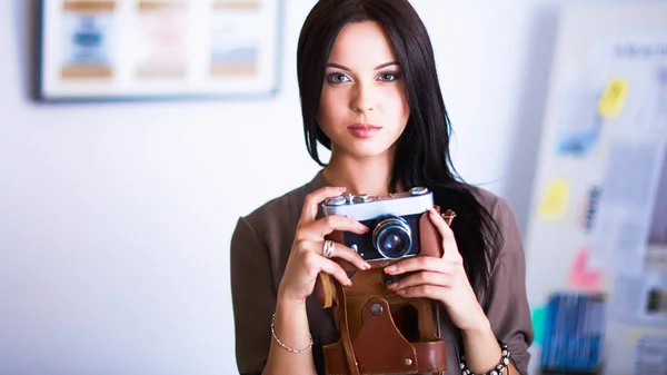 Young woman watching footage on film, standing near window — Stock Photo, Image