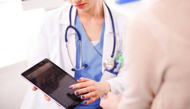 Doktor ve hasta masada otururken bir şey tartışıyorlar. Tıp ve sağlık hizmetleri kavramı. Doktor ve hasta.