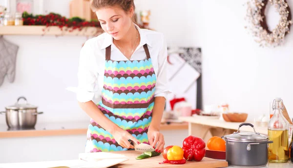 Femme souriante tenant son téléphone portable dans la cuisine. Femme souriante . — Photo