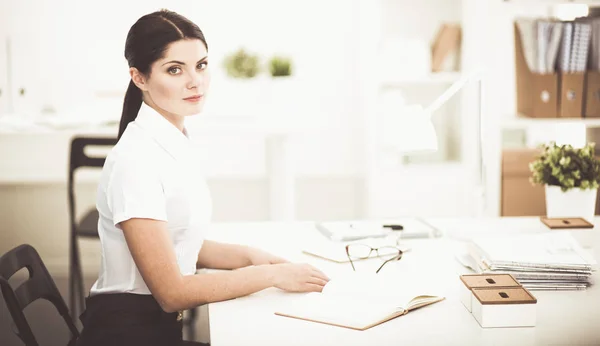 Attractive businesswoman sitting in the office, isolated — Stock Photo, Image