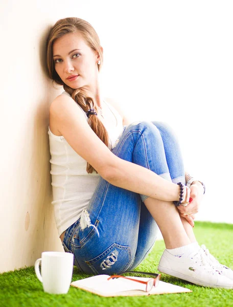 Beautiful woman sitting on the floor and holding a cup. Beautiful woman — Stock Photo, Image