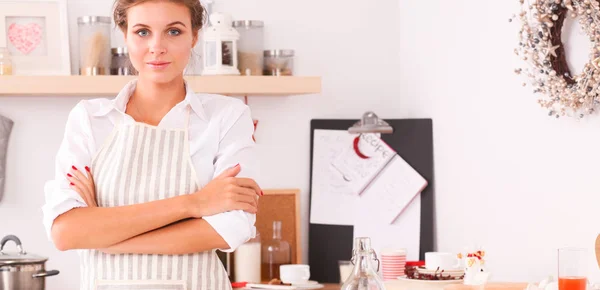 Mujer joven sonriente en la cocina, aislada en el fondo de Navidad —  Fotos de Stock