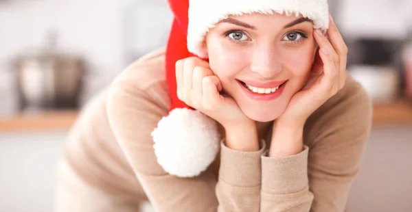 Mutfakta gülümseyen genç bir kadın, Noel arkaplanında soyutlanmış. — Stok fotoğraf