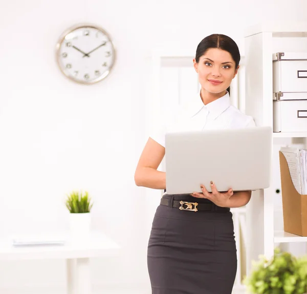 Attraente donna d'affari in piedi in ufficio con laptop — Foto Stock