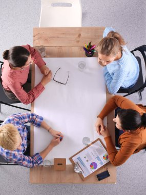 İş adamları toplantıda, ofiste oturup tartışıyorlar.